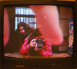 2 people photographing themselves in a TV screen